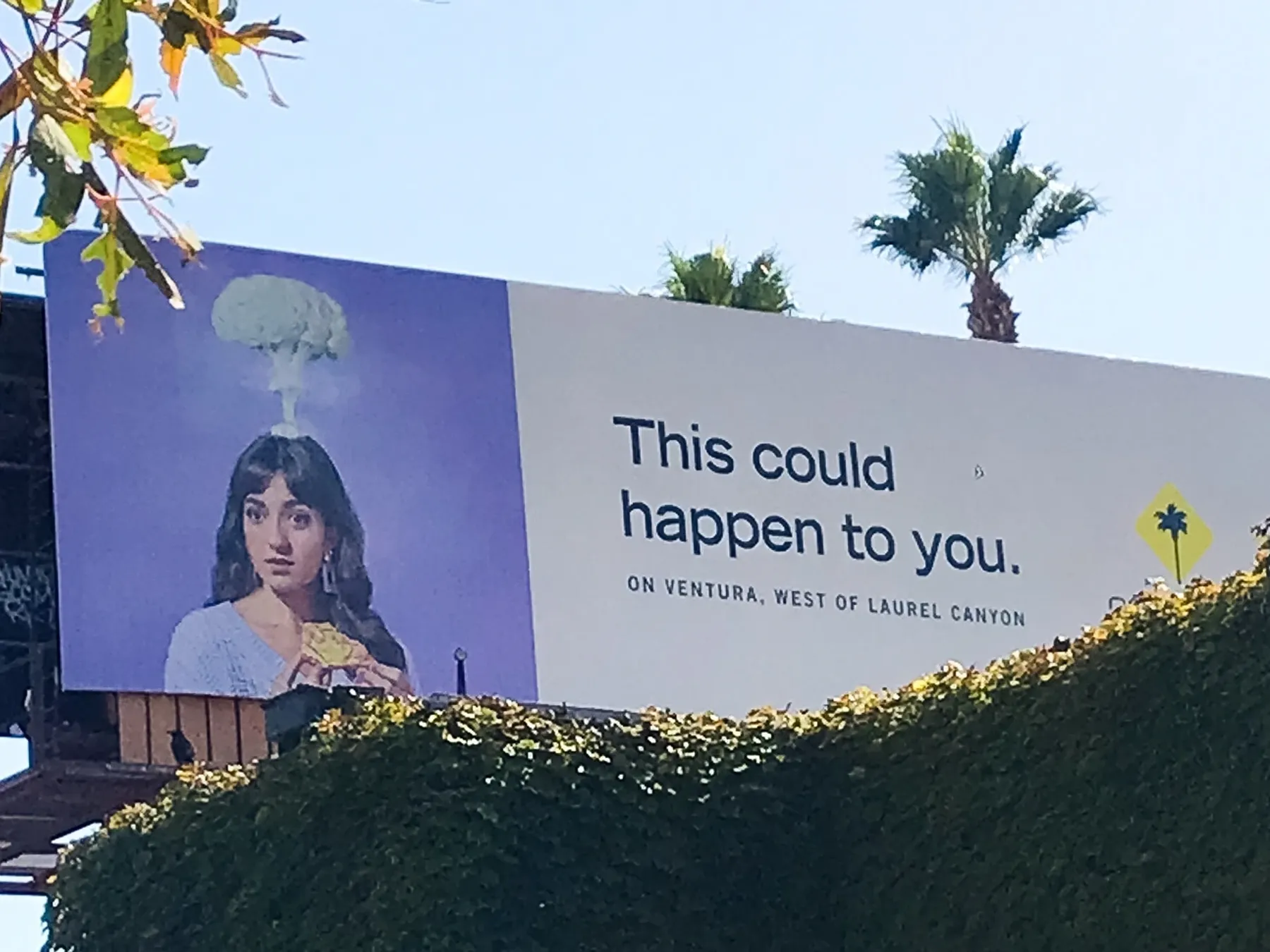Gabrielle DeCaro appears on a billboard holding a piece of pizza with an imaginary bomb erupting at the top of her head. The text reads: This Could Happen to You on Ventura, west of Laurel Canyon.