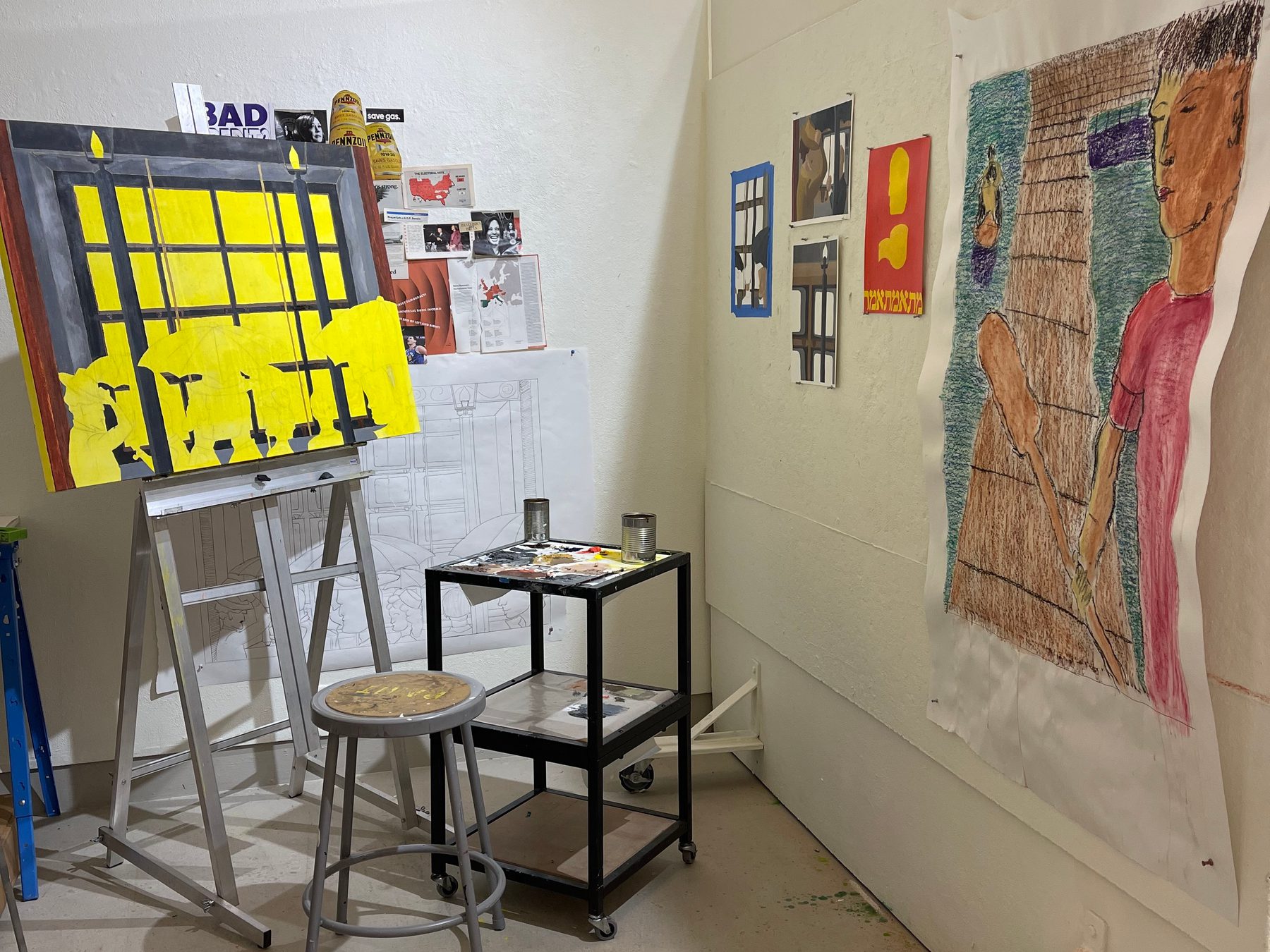 Studio space with artwork hanging on wall and easel with in progress painting.