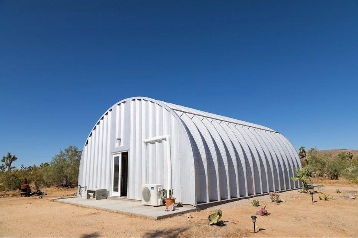 A white Quonset hut in a desert landscape