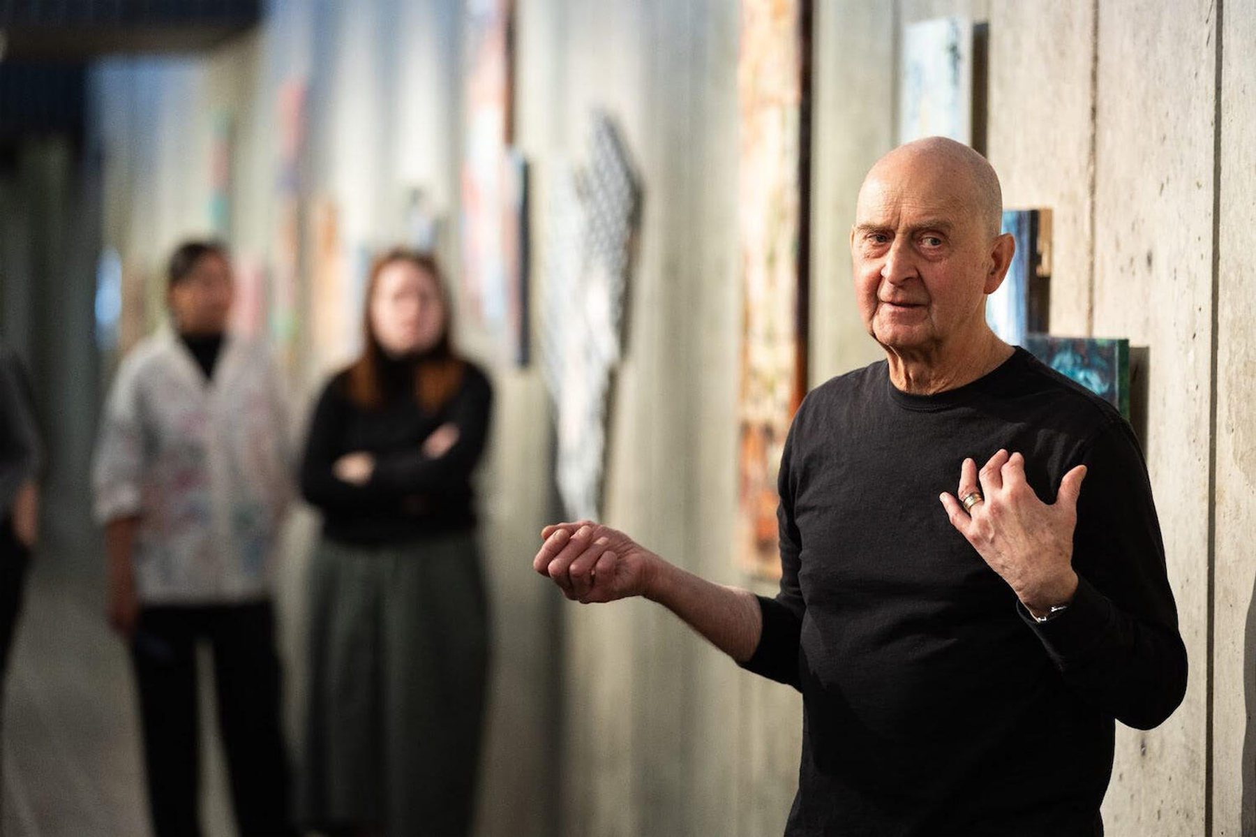 Jim Cogswell works with students to hang art on the walls of the Art & Architecture building